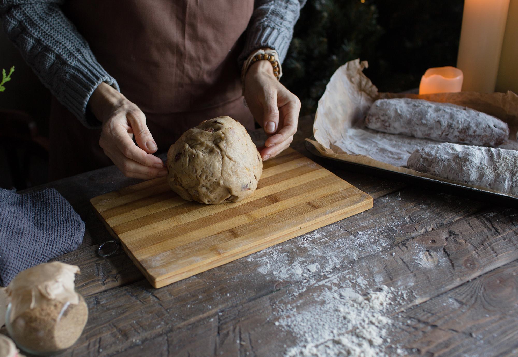 Close-up of hands kneading dough on wooden table
